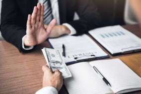 129142083-business-person-refusing-bribe-given-money-by-partner-with-anti-bribery-corruption-concept-